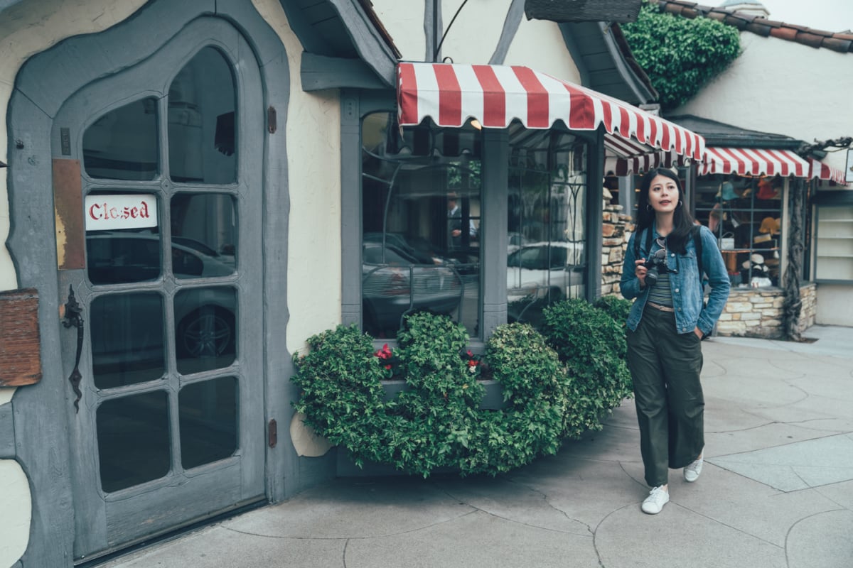 Woman walking through European-esque streets of Carmel, CA